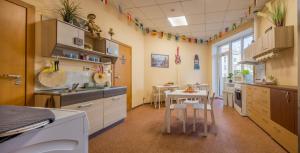 a kitchen with a table and a small table with chairs at Kaunas Center Hostel - Self-Check In in Kaunas
