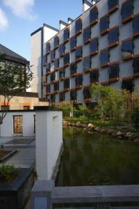 un edificio con un río frente a un edificio en Huangshan Xuanyuan International Hotel, en Tangkou