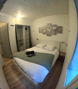 Un dormitorio con una cama con un sombrero negro. en Studio à 2 pas des thermes, en Saint-Martin-d'Uriage