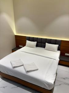 een slaapkamer met een groot bed met twee handdoeken erop bij HariPriya Executive in Tuljapur