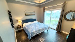 een slaapkamer met een bed en een groot raam bij 100 Steps to Beach Great Value Pool apts in South Padre Island