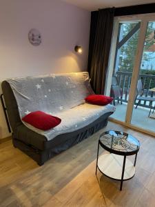 a bed with red pillows in a room with a table at Appartement 203 in Saint-Lary-Soulan +12 photos
