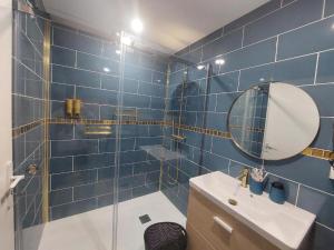 a blue tiled bathroom with a sink and a mirror at O Gîte d'anthony in Talizat +21 photos