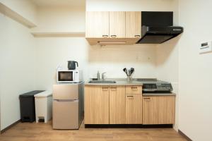 uma pequena cozinha com pia e micro-ondas em Bloomsbury 402 em Wada mais 27 fotografias