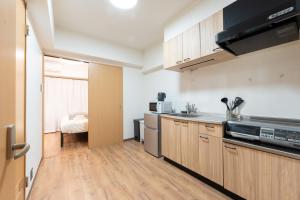 uma cozinha com armários de madeira e uma bancada em Bloomsbury 402 em Wada