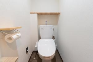 um banheiro com um vaso sanitário branco em um quarto em Bloomsbury 402 em Wada