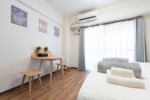 um quarto com uma cama, uma mesa e uma escrivaninha em Bloomsbury 402 em Wada
