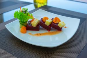 a white plate with food on a table at Heaven Breeze Hotel Ella in Ella