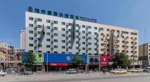 un gran edificio blanco en una calle de la ciudad con coches en GreenTree Inn Shenyang Shenhe District Wuai Street, en Shenyang