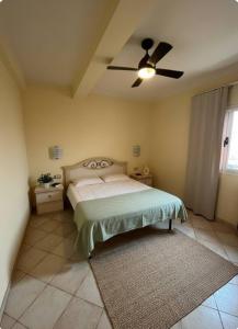 Un dormitorio con una cama y un ventilador de techo. en Seaside apartment in Shell Beach, en Santa Maria