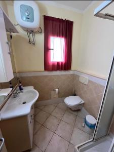 Un baño con inodoro, lavabo y ventana. en Seaside apartment in Shell Beach, en Santa Maria 5 fotos más