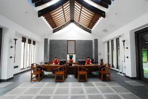 two people sitting at tables in a room with windows at Pingtian Bandao Hotel in Pai-sha-p'u
