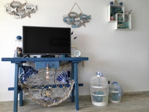 TV en una mesa azul en una habitación en Sun & Sea 511, en Sesimbra