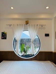 a bedroom with a round window with a plant at Cozy Haven Nest - Không gian mở, đầy ánh sáng in Yên Bái