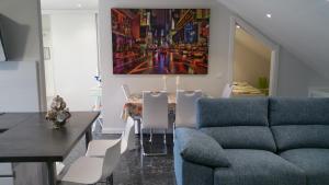 a living room with a couch and a table with chairs at Apartamento Castrelos in Vigo