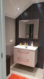 Un baño con un lavabo blanco y un espejo. en Apartamento Castrelos, en Vigo