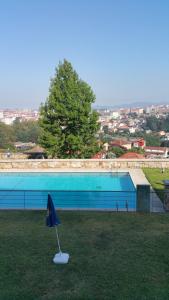 a blue umbrella sitting in the grass next to a pool at Apartamento Castrelos in Vigo