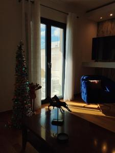 ISLAND Time Deluxe Apartment Downtown 3 floors في خيوس: غرفة معيشة مع شجرة عيد الميلاد أمام نافذة