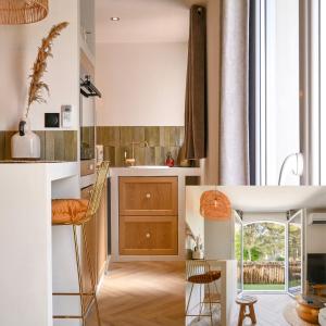 a kitchen with a sink and a counter with chairs at Une perle au bord de l'eau in La Ciotat