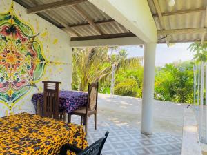 a table and chairs on a porch with a mural at Romaclan Villa in Midigama East