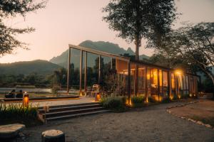 The Fam Cafe&Resort Chiangdao في تشينغ داو: بيت زجاجي مع جبال في الخلفية