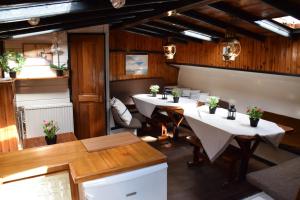 a restaurant with tables and chairs in a room at Boat-Apartment Rotterdam Fokkelina in Rotterdam +14 photos