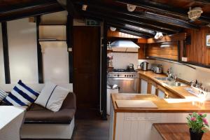 a kitchen with a couch and a sink and a stove at Boat-Apartment Rotterdam Fokkelina in Rotterdam