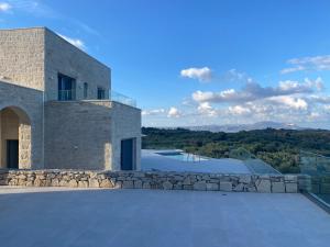 un edificio con un muro in pietra e una piscina di Carob Luxury Stone Villas a Gavalochori