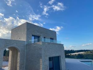 un edificio in mattoni con balcone sopra di Carob Luxury Stone Villas a Gavalochori
