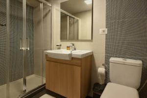 a bathroom with a toilet and a sink and a shower at Shade Suites & Studios in Beirut +65 photos
