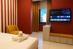 a hotel room with a bed and a flat screen tv at Shade Suites & Studios in Beirut