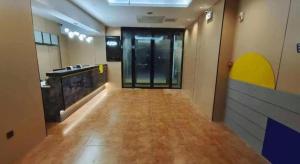 um corredor vazio de um prédio com uma sala com portas de vidro em 7 Days Inn Tianjin Anshan West Road Tianjin University em Tianjin