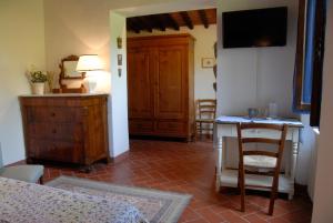 a room with a bedroom with a table and a television at Canto dei Merli in Greve in Chianti