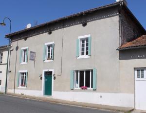 a house with a green door on a street at Fleur de Lys in Ansac-sur-Vienne