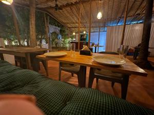 una mesa de madera con dos platos y vasos. en Nature's Inn Luxury Villa Morjim Goa, 4bhk and Sparkling Pool, en Morjim