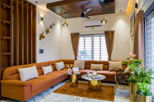 una sala de estar con un sofá y una mesa en Ayush villa, en Udaipur
