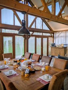 Chambres d'hôtes chez l'habitant - Bed & Breakfast homestay في Huisnes-sur-Mer: غرفة طعام مع طاولة خشبية عليها طعام