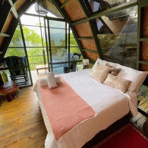 ANCESTRAL GLAMPING في باربوسا: غرفة نوم بها سرير في غرفة بها نوافذ