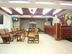 a waiting room with wooden chairs and a tv at An Dong Center Hotel Chinatown Saigon in Ho Chi Minh City