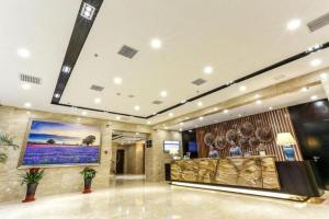a lobby of a hotel with a large painting on the wall at Lavande Hotel Tianjin Binhia Yujiabao Finance Center Branch in Binhai