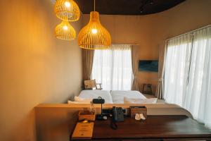 The Fam Cafe&Resort Chiangdao في تشينغ داو: غرفة نوم بسرير مع مصباحين ومكتب