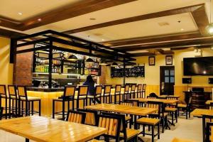 um restaurante com mesas e cadeiras de madeira e um bar em Cebu Northwinds Hotel em Cebu