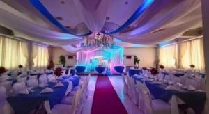 um salão de banquetes com cadeiras brancas e um lustre em Cebu Northwinds Hotel em Cebu