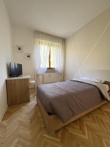 um quarto com uma cama grande e uma televisão em Appartamento DIMORA GUIDI 3 camere 2 bagni URBINO em Urbino