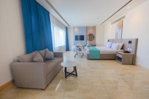a hotel room with a bed and a couch at Flow Spectrum Resort Sahl Hasheesh in Hurghada