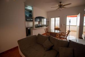 a living room with a couch and a kitchen with a table at Vila Vistazul in Pataias