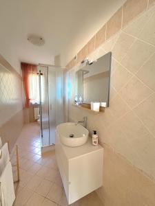 um banheiro branco com uma pia e um espelho em Appartamento DIMORA GUIDI 3 camere 2 bagni URBINO em Urbino mais 26 fotografias