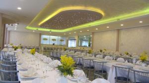 a large banquet hall with white tables and chairs at Hotel Ristorante Sbranetta in Rozzano