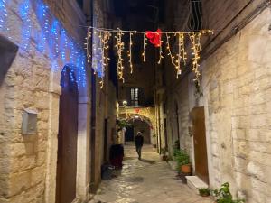 een man loopt door een steegje met kerstverlichting bij DaDa' Home in Trani