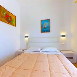 Un dormitorio con una cama grande con dos mesitas de noche. en Mateo Rooms, en Himare